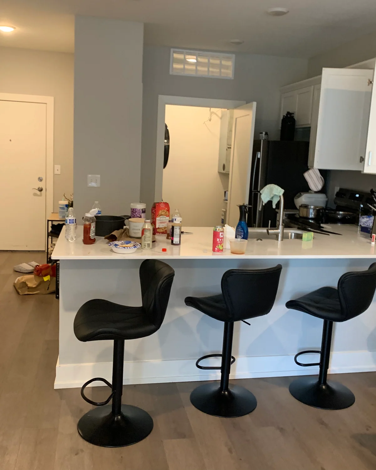 Client-supplied kitchen photo showing dishes, bottles, and other items across the counter.